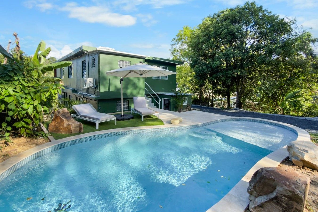 A swimming pool with lounge chairs and a building in the background.