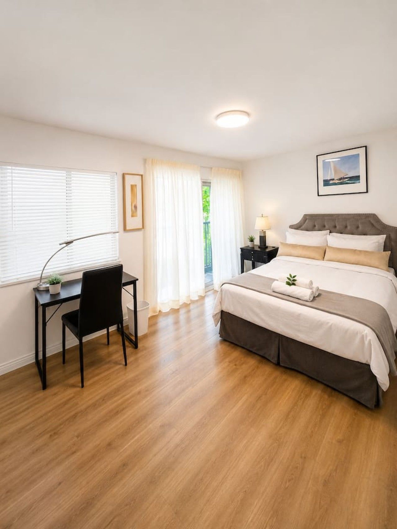 A bedroom with a bed, a desk, and a chair.