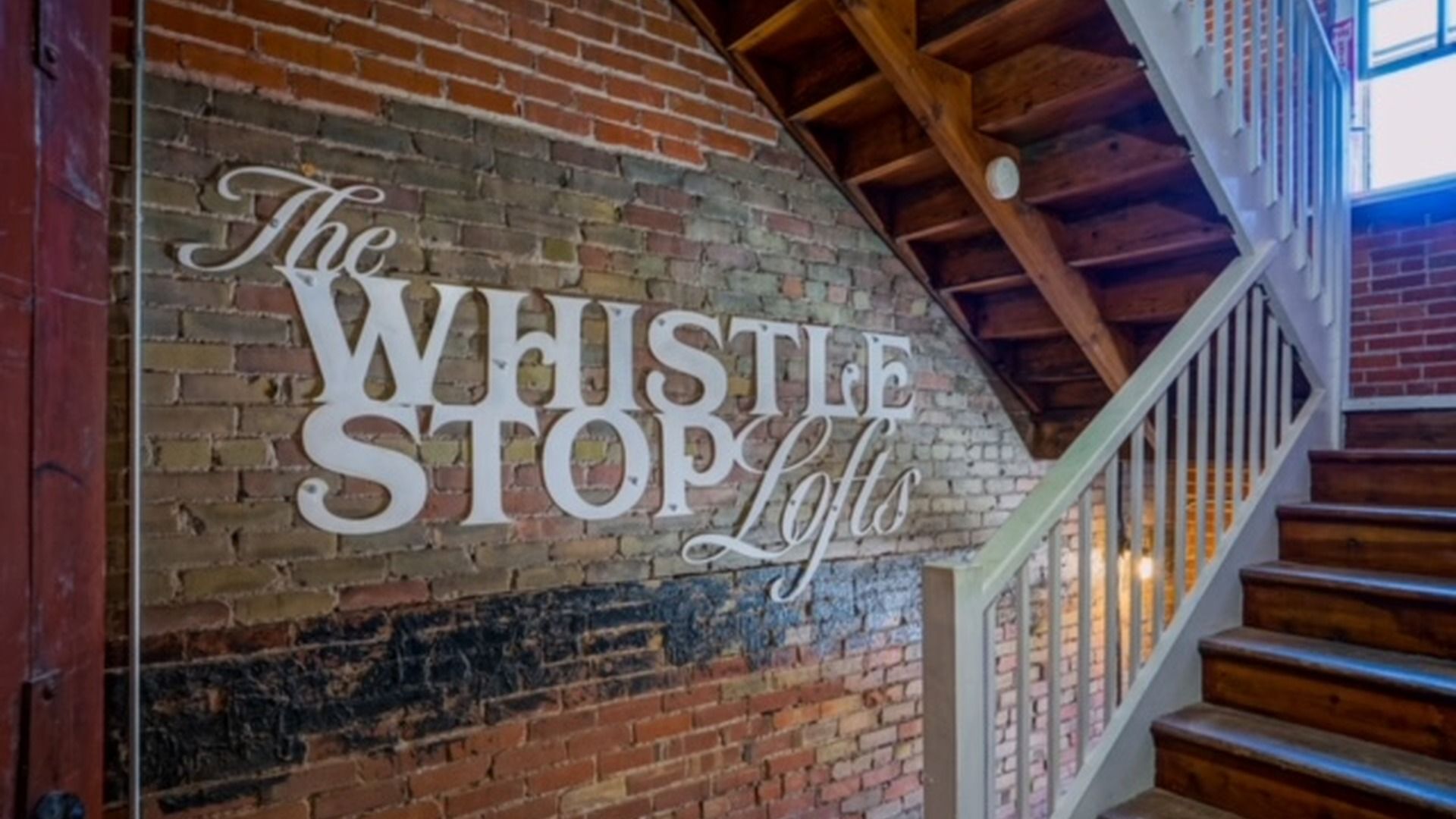 A brick wall with a sign reading 'The Whistle Stop Loft'.