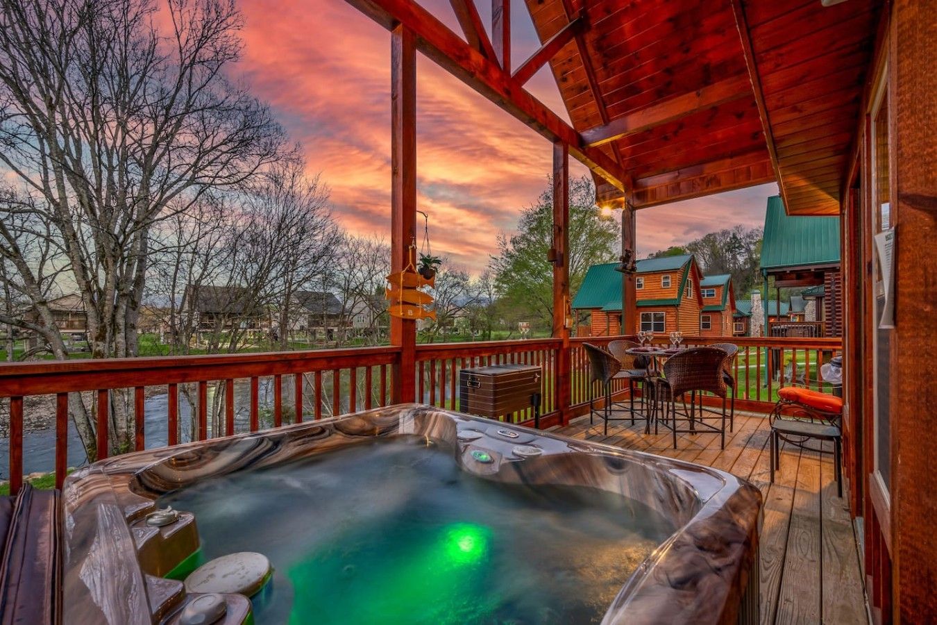 A hot tub on a wooden deck with a view of houses and trees.