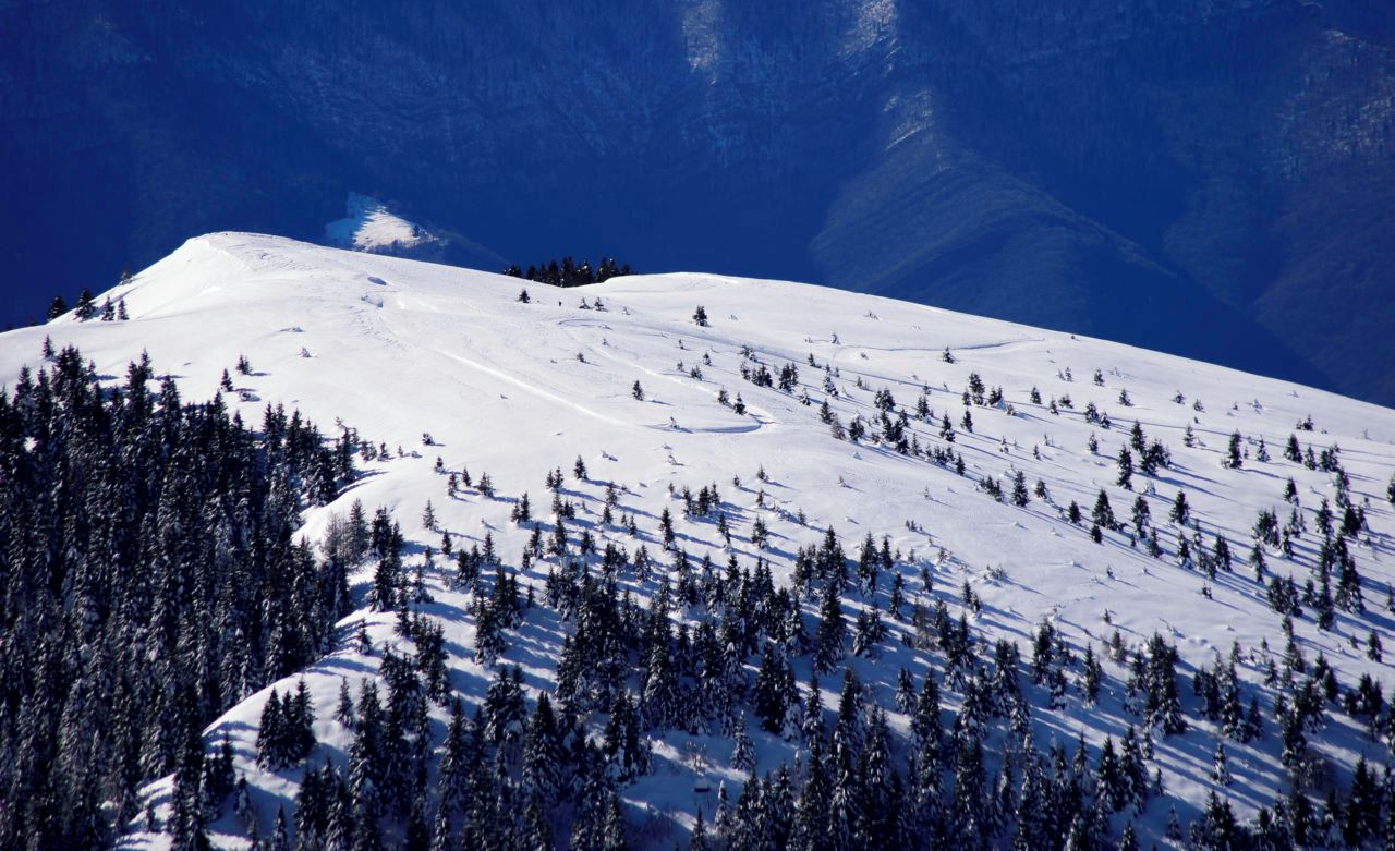 A snow-covered mountain with a clear sky.