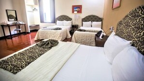 A hotel room with two beds, a desk, and a chair. There is a window providing natural light and a framed picture on the wall. - Mérida Made for Groups | 3 Double Beds + Pool (Mérida)