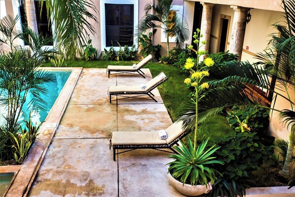A poolside area with lounge chairs and potted plants. - Explore Mérida, Then Take a Dip | Cozy Double Room (Mérida)
