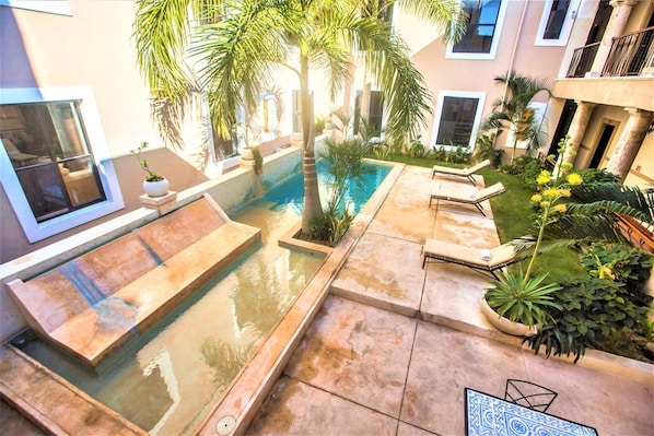 A pool area with a hot tub, lounge chairs, and palm trees. - Experience Mérida Your Way | Comfortable Stay + Pool (Mérida)