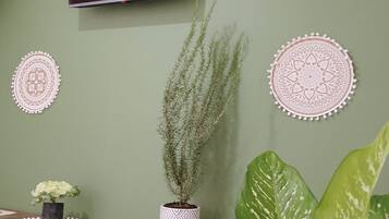 Une pièce dotée d’un téléviseur à écran plat fixé sur un mur vert, le tout agrémenté de décorations murales.