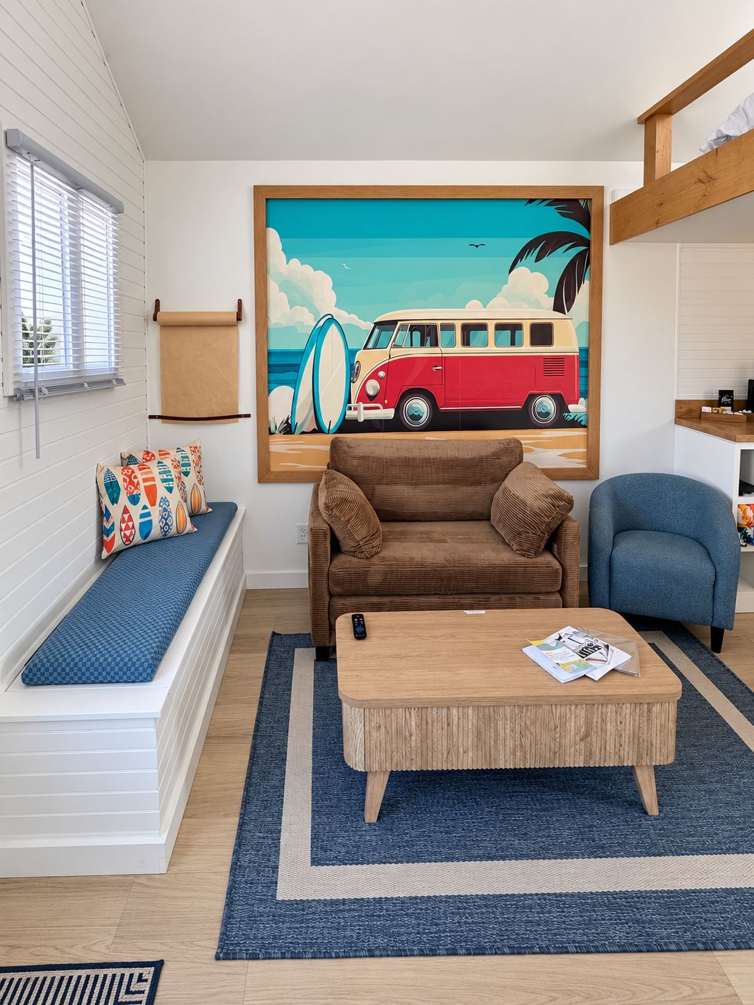 A living room with a brown sofa, a blue armchair, a wooden coffee table, and a colorful painting of a van on the wall.