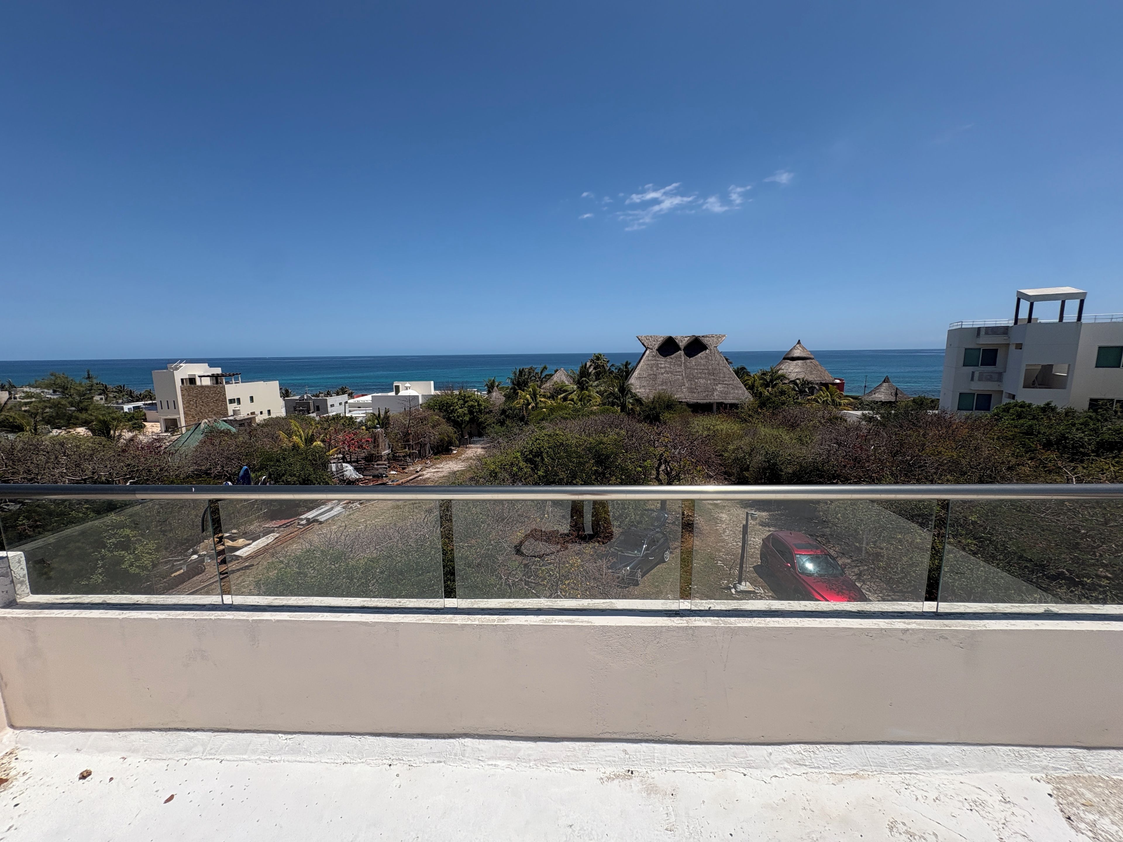 Uma varanda com vista desobstruída para o mar e edifícios.