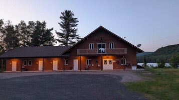Un chalet à deux étages doté d’un balcon, d’un comptoir d’accueil et offrant une vue sur la forêt environnante.