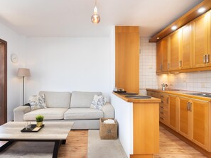 A modern kitchen with wooden cabinets, a built-in island, and a light fixture. - CHL Casa Arthur, El Médano beach penthouse (El Médano)
