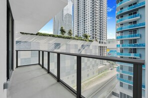 A balcony with a view of high-rise buildings and a railway track. - The Crosby by Ilios Rentals (Miami)