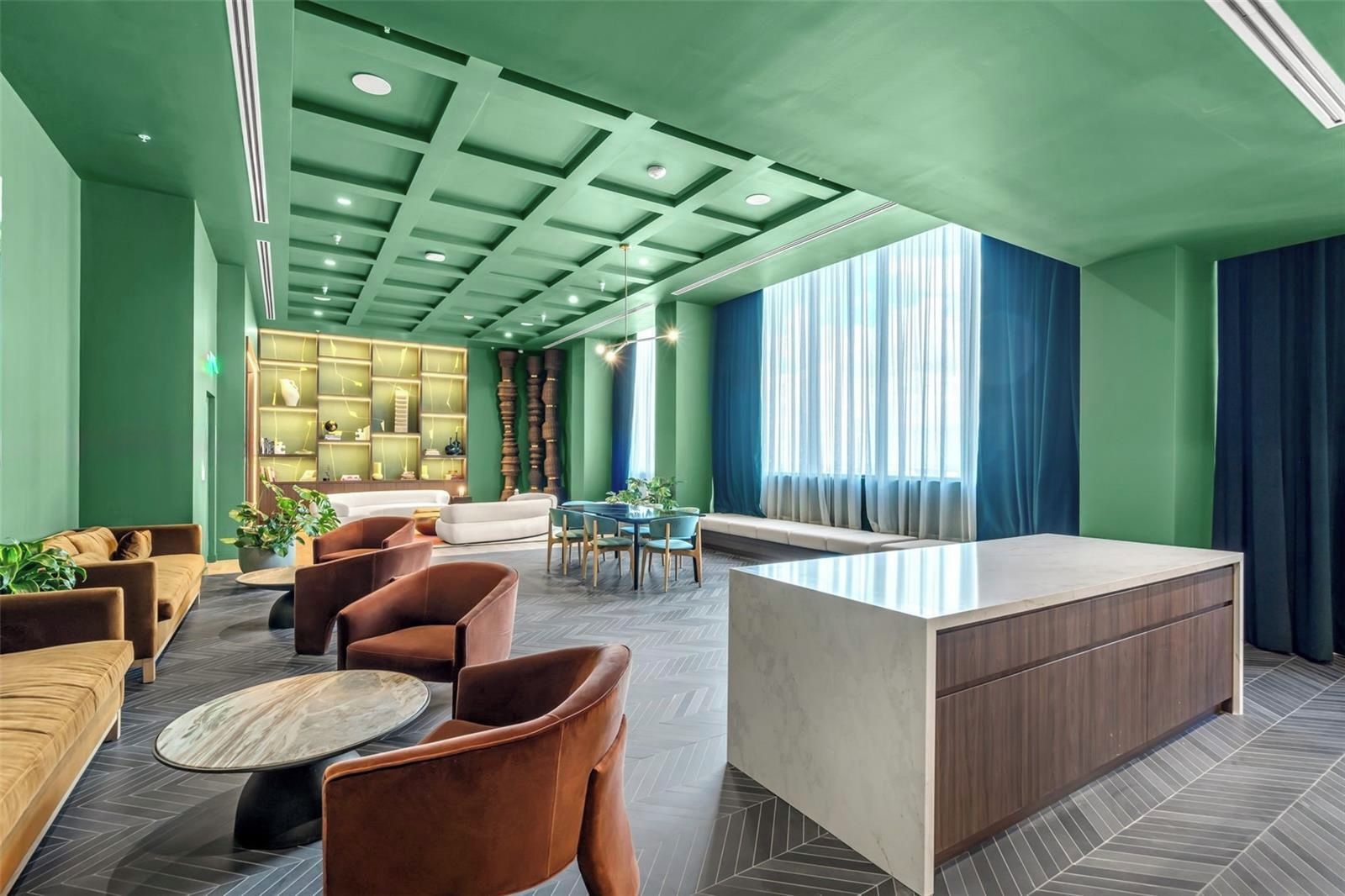 A modern lobby with a reception desk, seating area, and a decorative bookshelf.