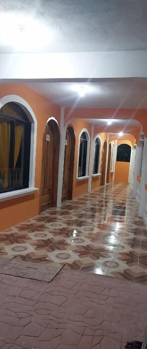 Un pasillo con arcos y suelo estampado.