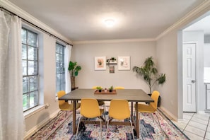 Ein Esszimmer mit Tisch, Stühlen und einem gemusterten Teppich.