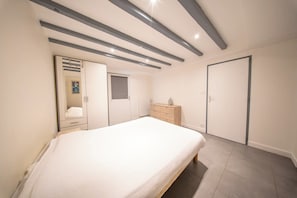 A bedroom with a bed, a dresser, a wardrobe, and a mirror. - Maison de Famille Vue Mer - Port & Côte Sauvage (Quiberon)