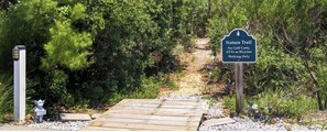 A wooden boardwalk leading to a nature trail with a sign indicating no golf carts, ATVs, or bicycles, only walking allowed. - Charming Family Beach House in Gulf Shores - Rookery 3 (Gulf Shores)
