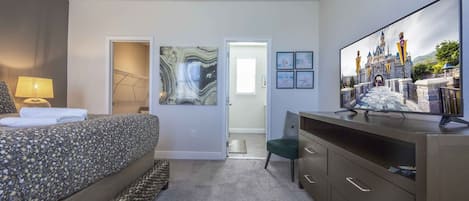 Una habitación de hotel con cama, escritorio, televisión y obras de arte en las paredes.