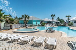 Ein Poolbereich mit Liegestühlen, einem kleinen Pool und einem Gebäude mit blauem Dach.