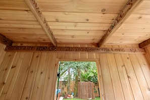 A wooden ceiling with carved text and a doorway leading to an outdoor area. - HOPEWELL OASIS - TAMPA / Your Private Wellness Retreat with Hot Tub & Sauna (Tampa)