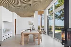Een modern interieur met een eethoek, een bank en een open haard.