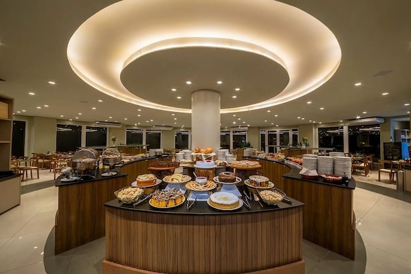 A buffet area with a central column and multiple food stations.