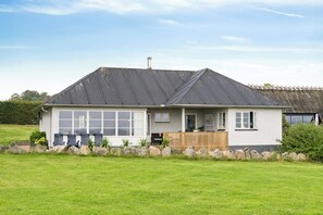 A two-story house with a large front porch, a garage, and a well-maintained lawn. - Holiday home near the water on beautiful Als (Augustenborg)