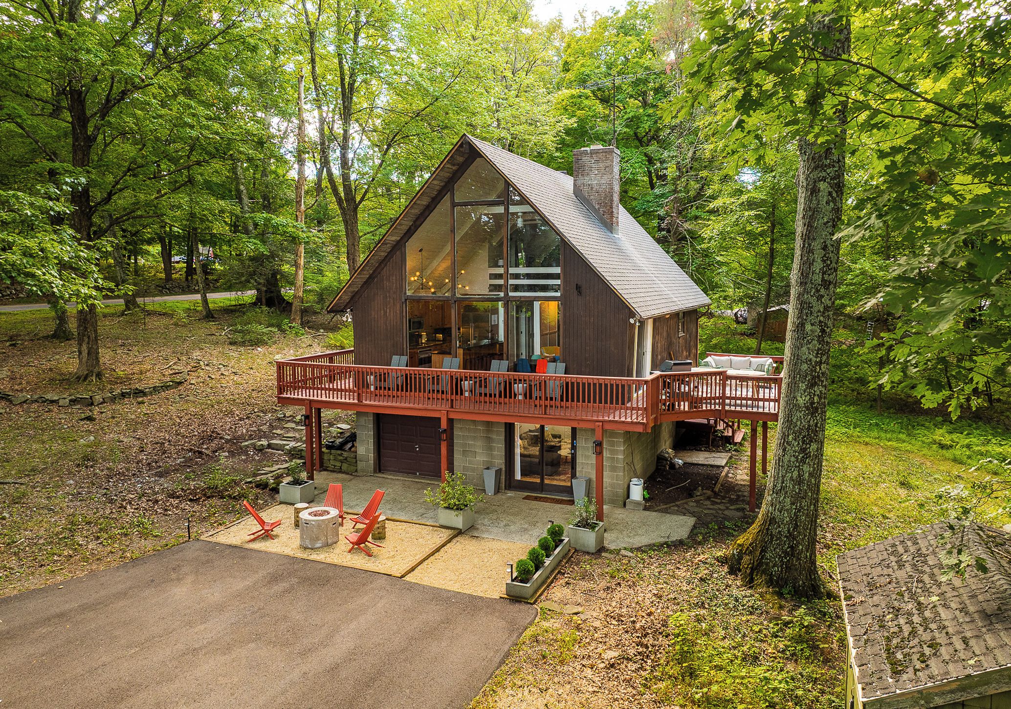 Une cabane dotée d’une terrasse, entourée d’arbres.