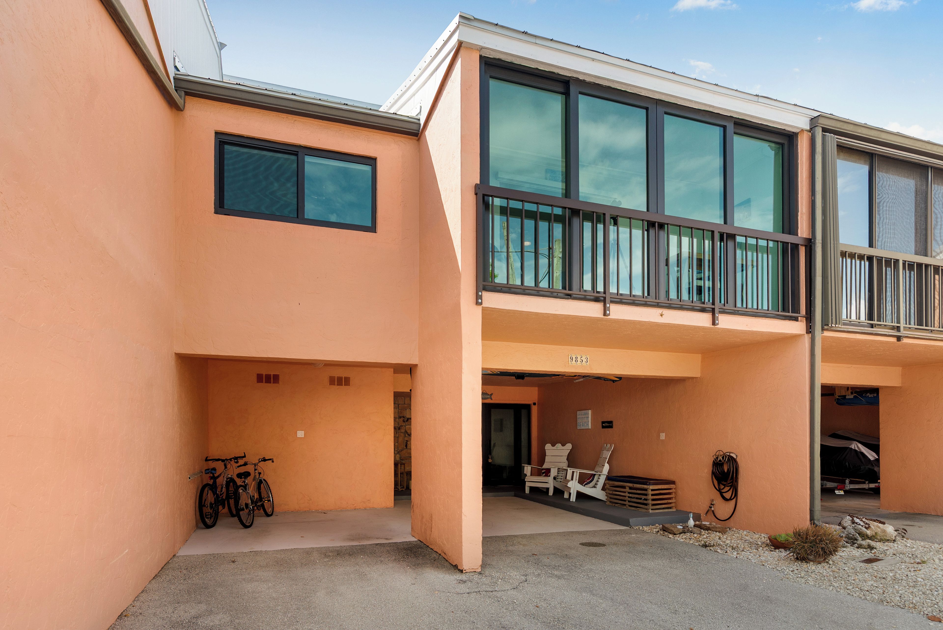 A modern building with a flat roof, large windows, and a balcony.