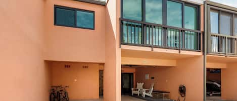 A modern building with a flat roof, large windows, and a balcony.