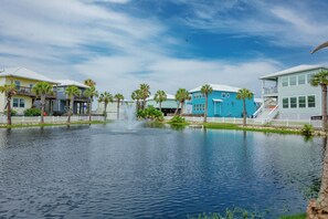 Um imóvel à beira-mar com piscina, fonte e fileira de casas coloridas.