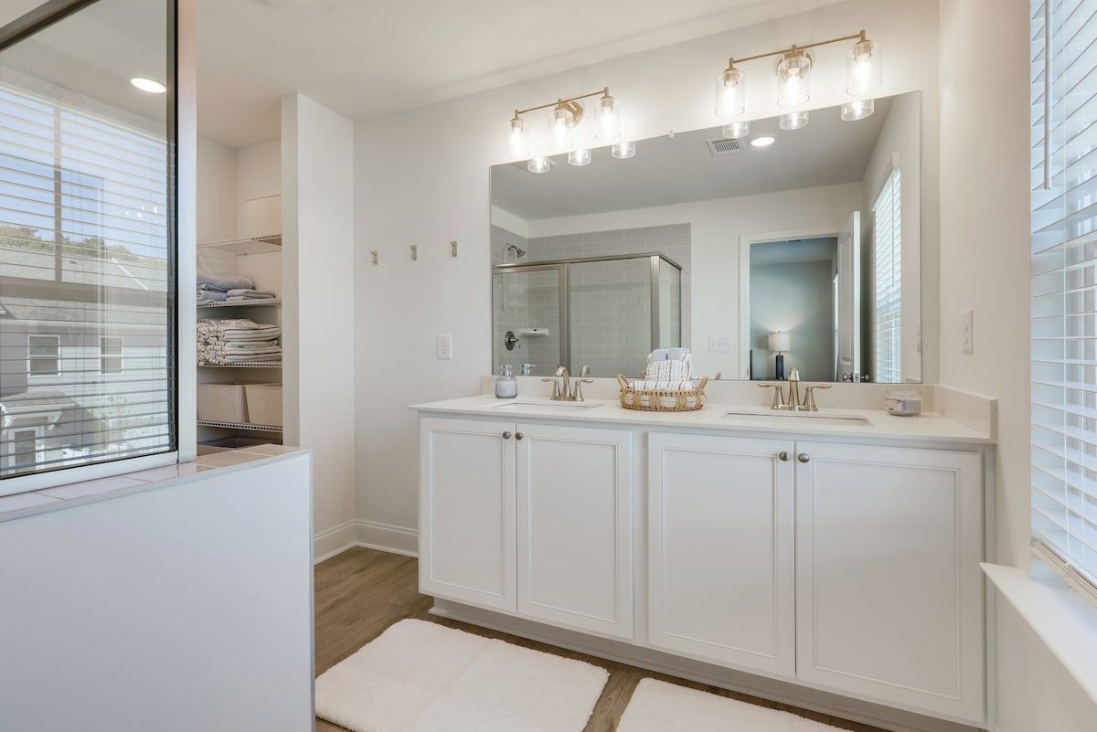 Un bagno moderno con un ampio lavabo, cabina doccia in vetro e uno specchio grande.