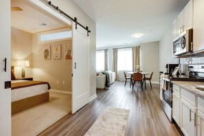 Apartamento moderno com cozinha, sala de jantar e um quarto com porta deslizante.