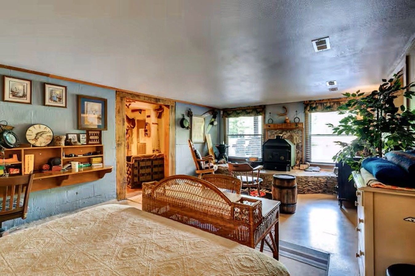 Una habitación acogedora con cama, chimenea, estantería y zona de comedor.