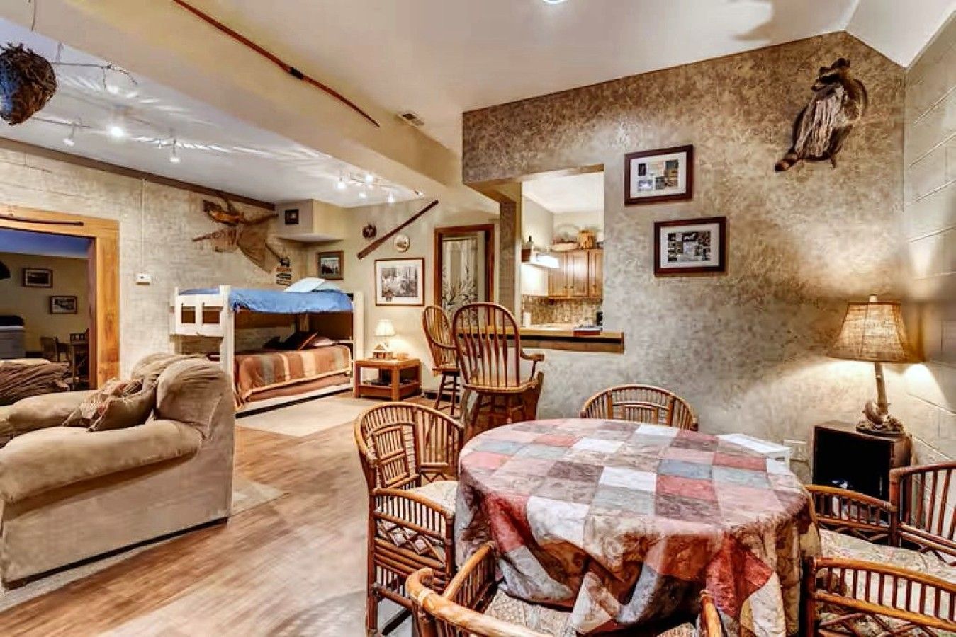 A cozy room with a bunk bed, a dining table with chairs, and a fireplace.