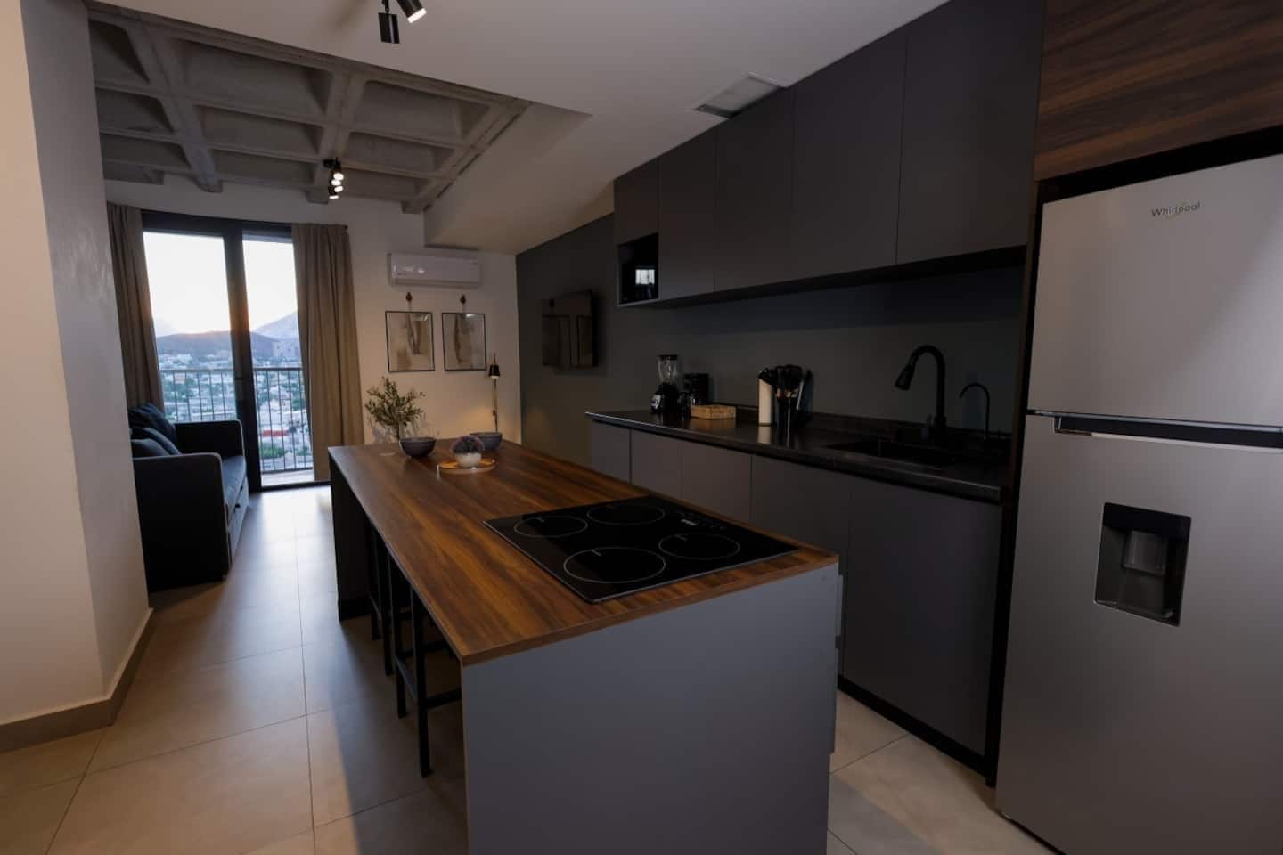 A modern kitchen with a central island, built-in appliances, and a view to the outside.