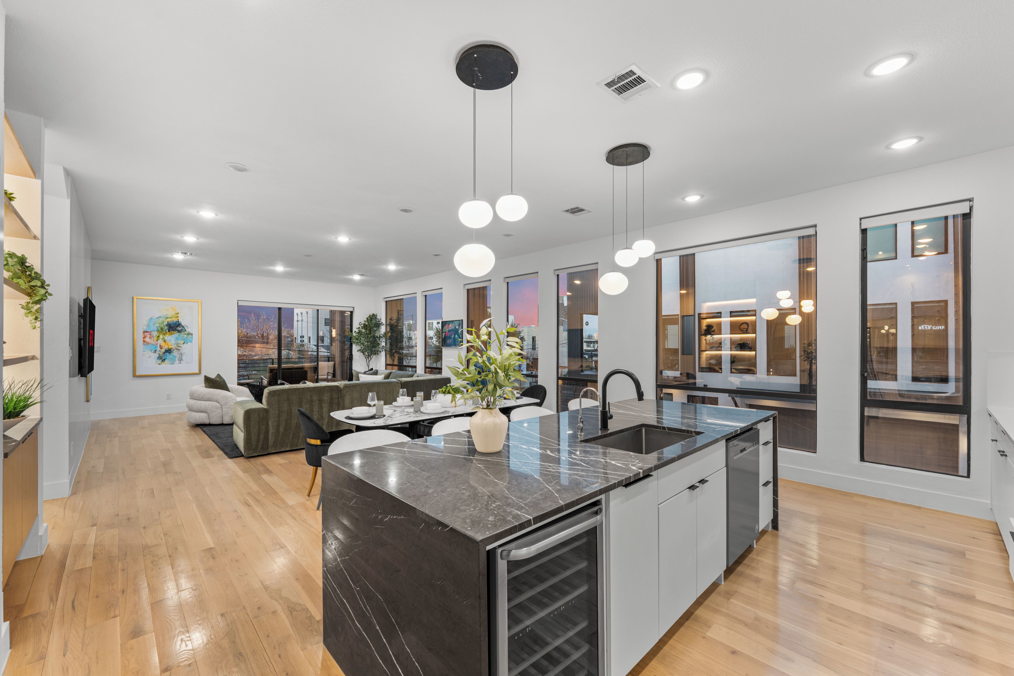 A modern kitchen with a central island, built-in appliances, and pendant lighting.