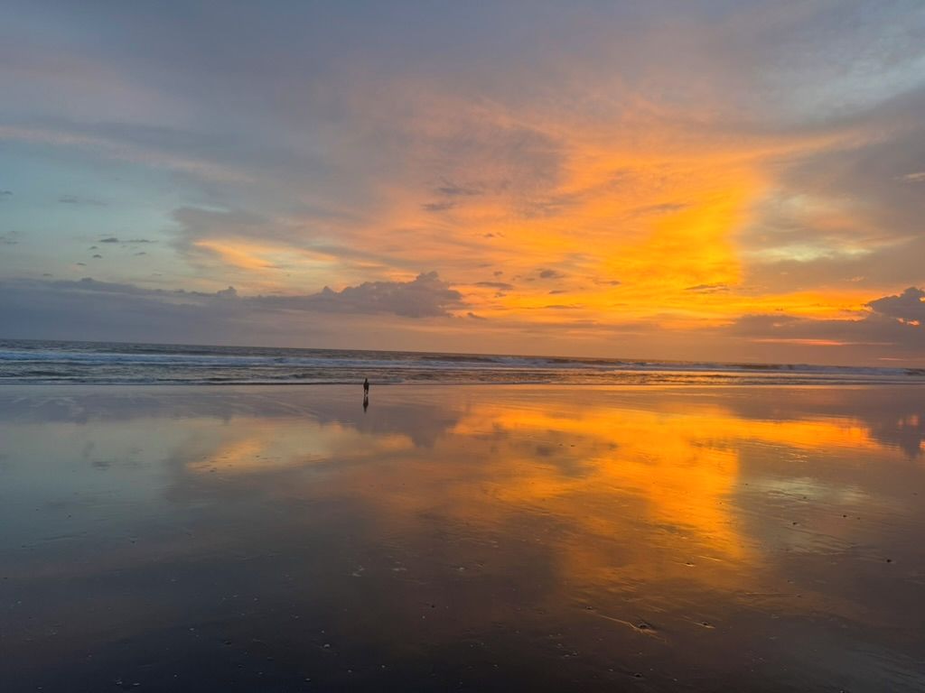 Una playa con un mar tranquilo y un cielo al atardecer.
