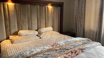 Een bed met hoofdbord, kussens en dekbed.