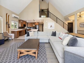 A spacious living area with a large sectional sofa, a wooden coffee table, and a kitchen in the background. - Spacious Avon Townhome - Views of Beaver Creek (Avon)