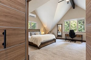 A bedroom with a sloped ceiling, a bed, a desk, and a large window. - Spacious Avon Townhome - Views of Beaver Creek (Avon)