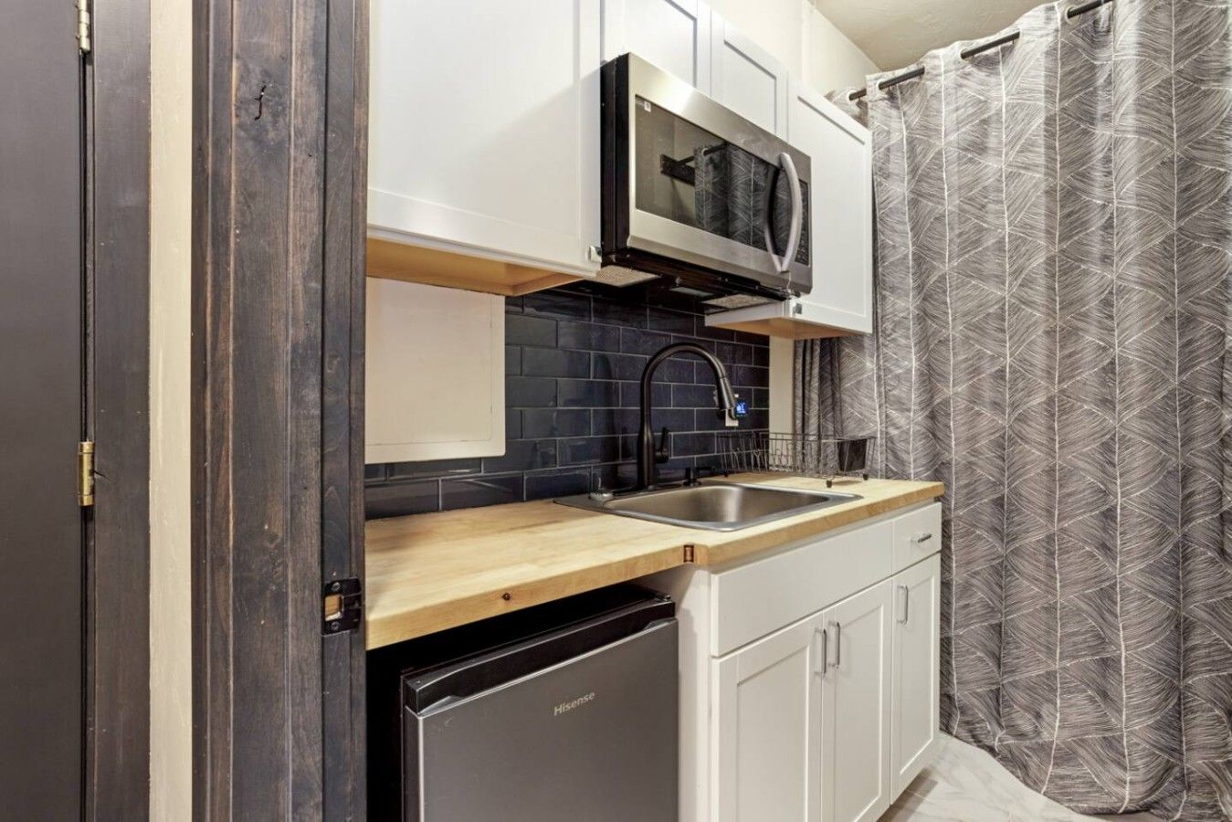 A compact kitchen with a microwave, sink, and dishwasher.