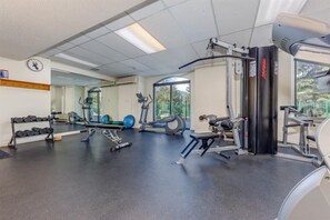 A gym with various exercise equipment, including dumbbells, a bench, and a treadmill. - Mountain views | Ski-in/out | Pool, hot tub & gym (Whistler)