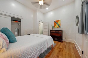 A bedroom with a bed, dresser, and a door leading to another room. - Charming & Cozy / 1 BR 1 BA / Historic Duplex (Tucson)