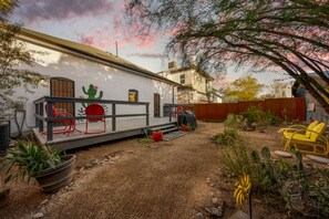 A patio area with a red chair, a yellow chair, and a cactus plant. - Charming & Cozy / 1 BR 1 BA / Historic Duplex (Tucson)