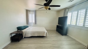 A bedroom with a bed, a ceiling fan, a TV, and a window. - Clean, Quiet & Cozy Housing in Summerlin, convenient to Red Rock National Park (Las Vegas)