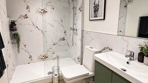 Une salle de bain moderne équipée d’une douche, de toilettes et d’un lavabo.