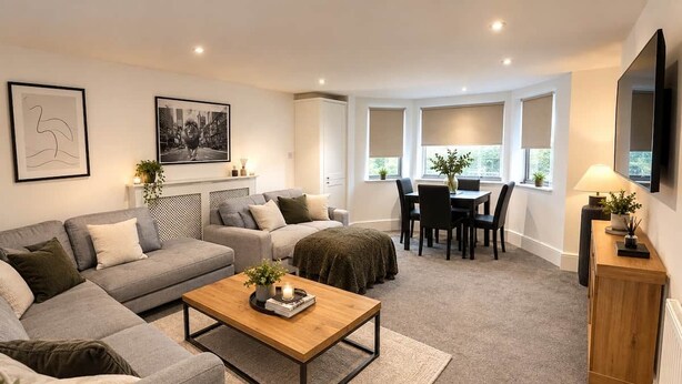Un salon moderne comprenant un ensemble de canapés, une table basse, un coin repas avec des chaises et une cheminée.