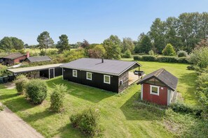 A residential property with a main house, a smaller red building, and a covered outdoor area. - Cozy holiday home in Klint – Nykøbing Sj. (Nykøbing Sjælland)