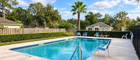 Una piscina rectangular con una escalera metálica, rodeada por una terraza de hormigón.