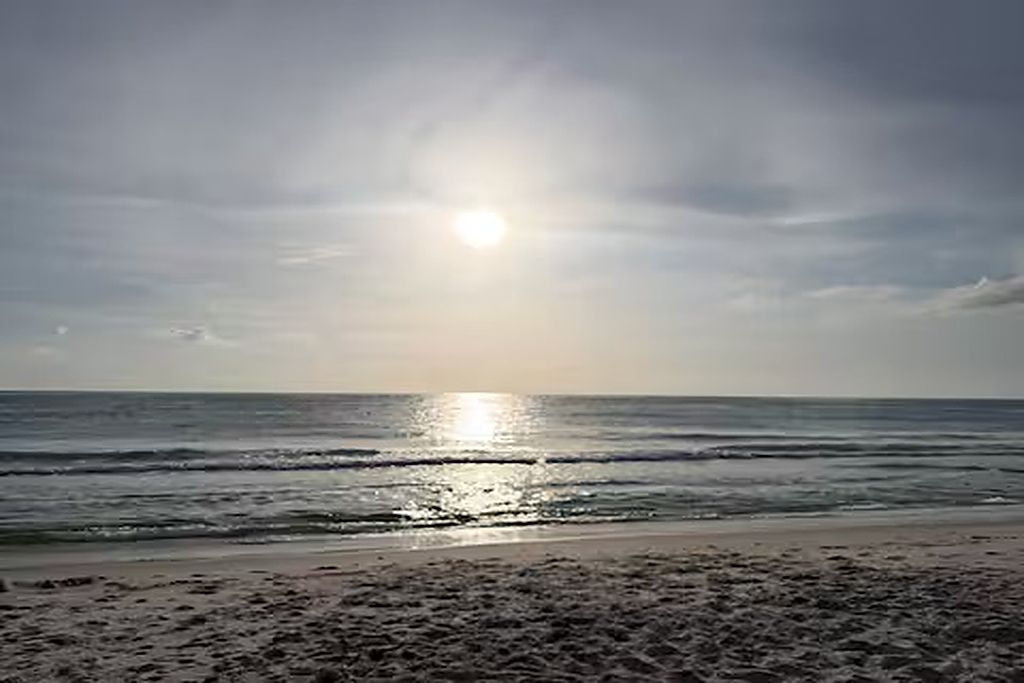 Una playa con olas y un cielo despejado.