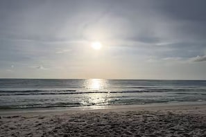 Ein Strand mit Wellen und blauem Himmel.